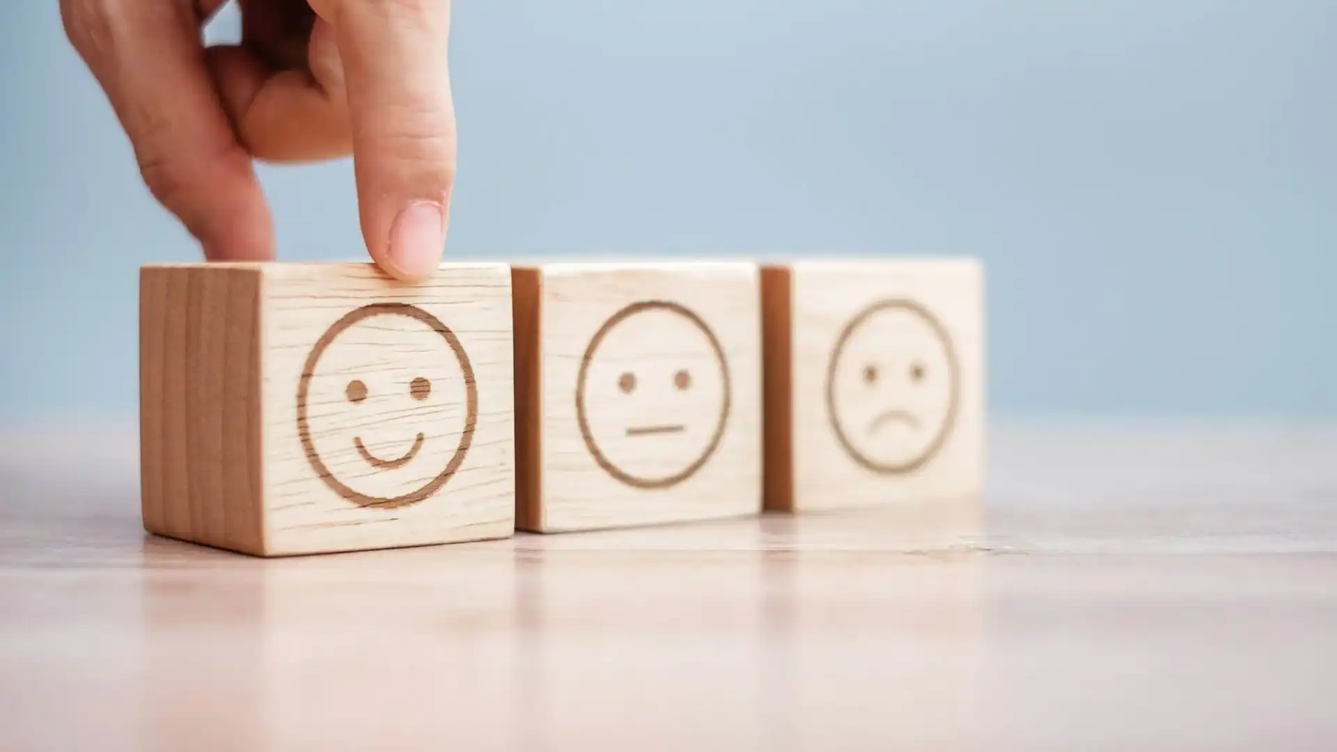 Man hand holding emotion face block. review, satisfaction and feedback concept